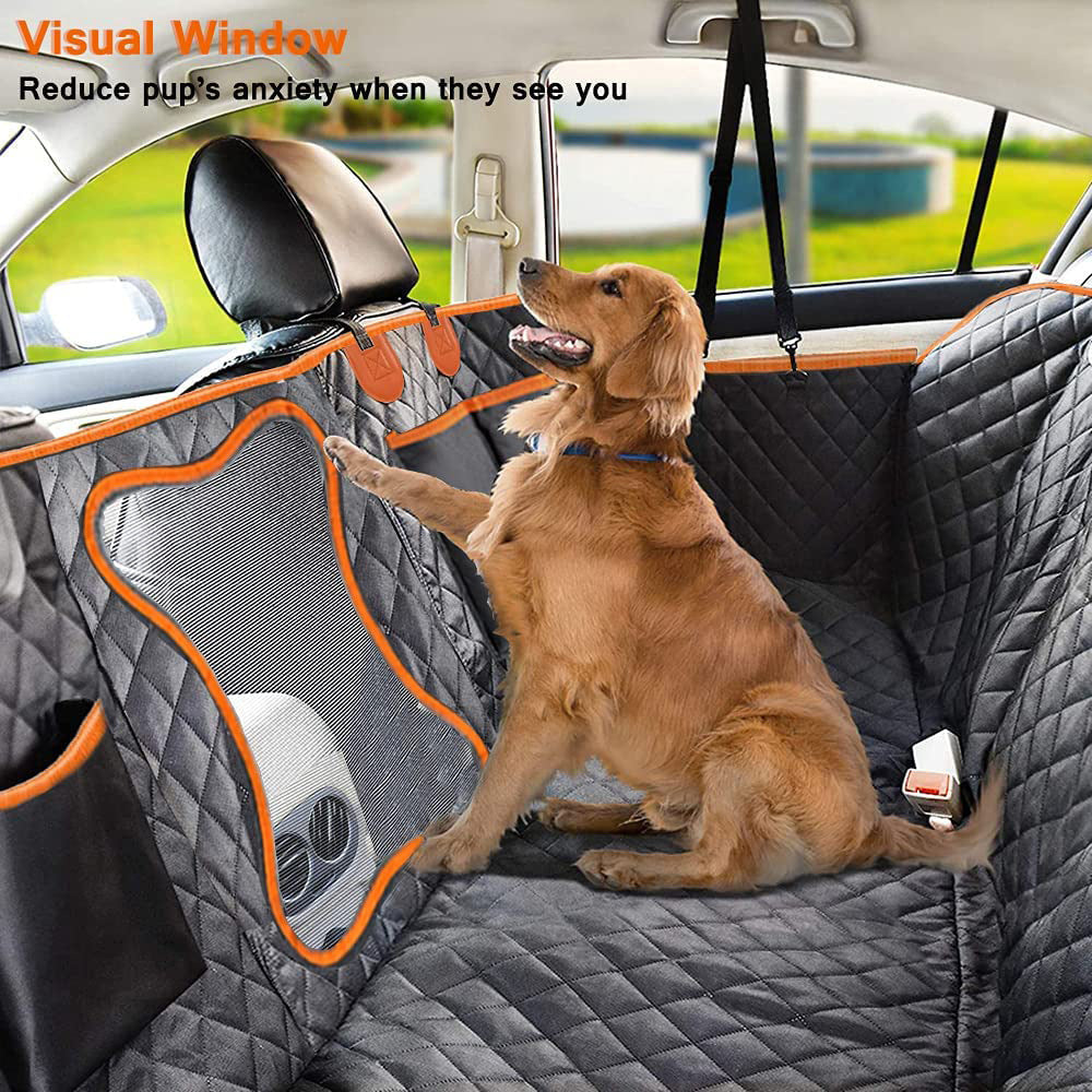 Golden retriever looking through the mesh window of the dog hammock in the back seat