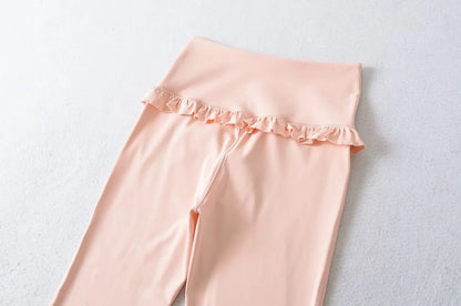 Ruffle hem detail positioned below the waistline on flared yoga pants