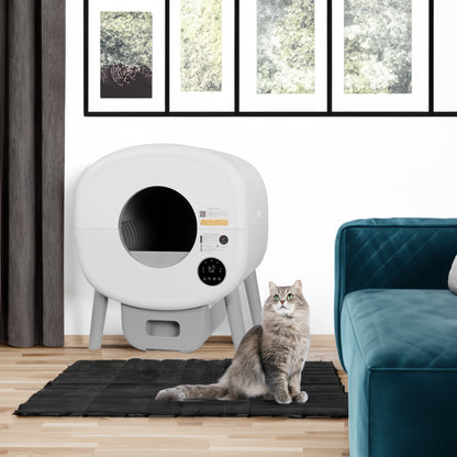 Self-cleaning smart cat litter box in a living room with a cat beside it